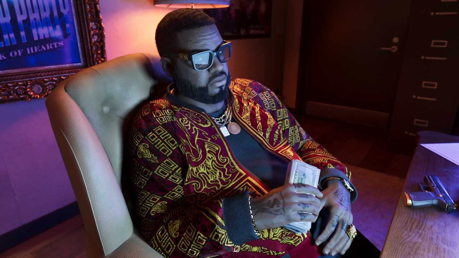 Boobie Ike sitting back in an office chair holding a stack of cash