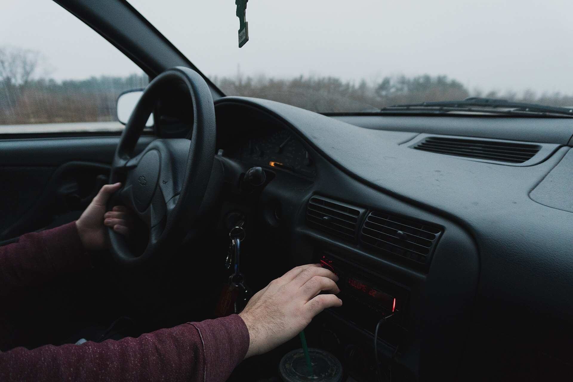 Hand tuning a car radio on the dashboard