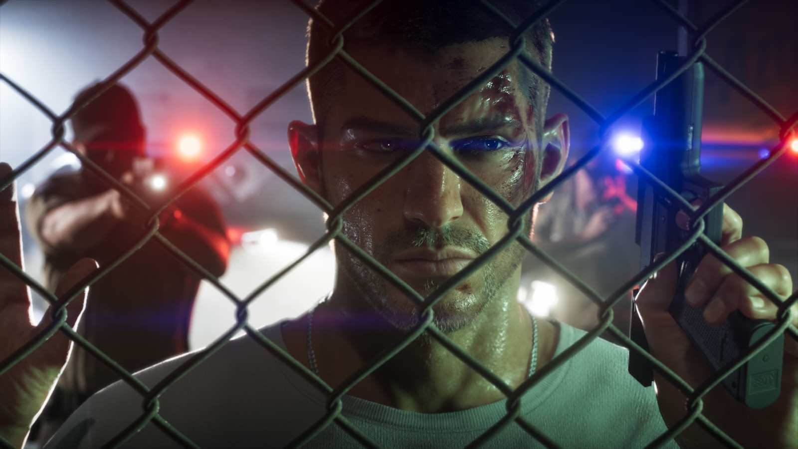 Jason behind a chain-link fence with police lights flashing behind him